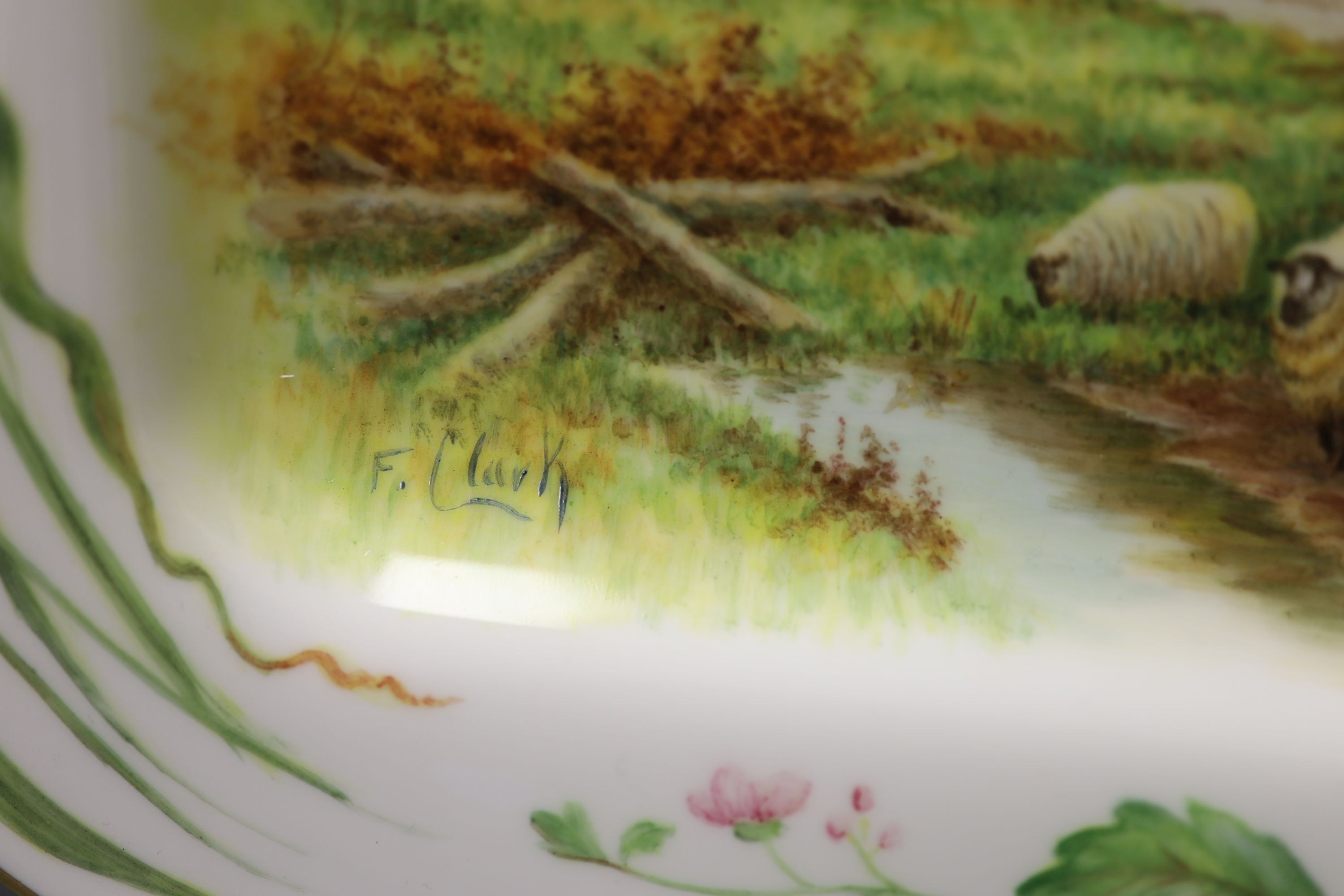 A rectangular dish with rounded corners painted with painted with sheep, a man and dog and a country house by Francis Clark, signed fro